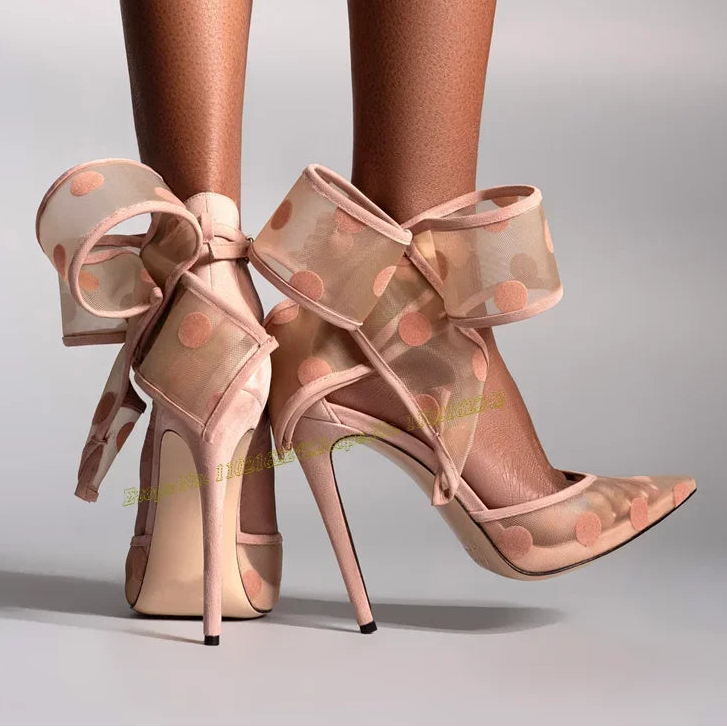 High-heeled shoes with polka dot design and sheer ribbon on a neutral background