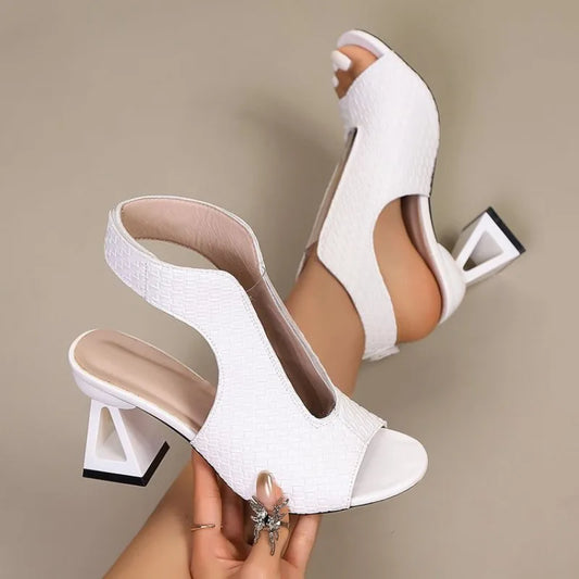 White high-heeled shoes being worn on a beige background