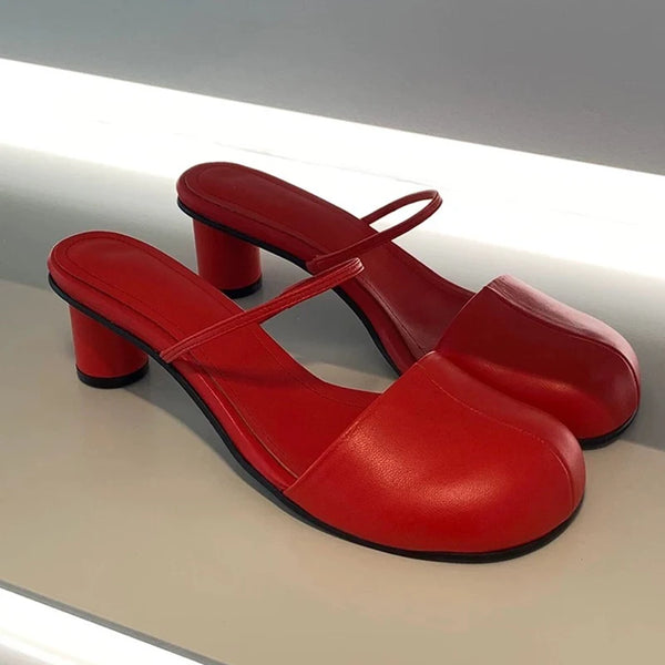 Red high-heeled shoes with a strap on a light gray background