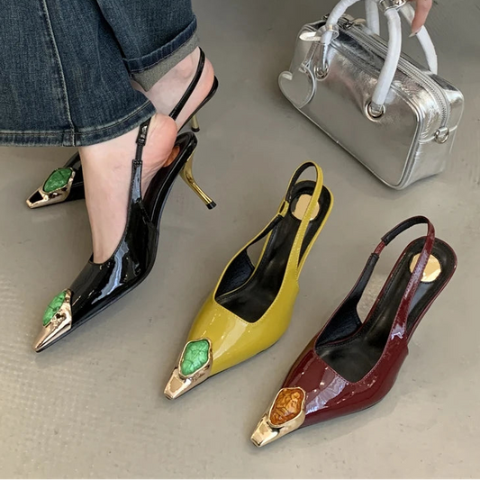 Black, yellow, and red high-heeled shoes with decorative elements on a neutral background.